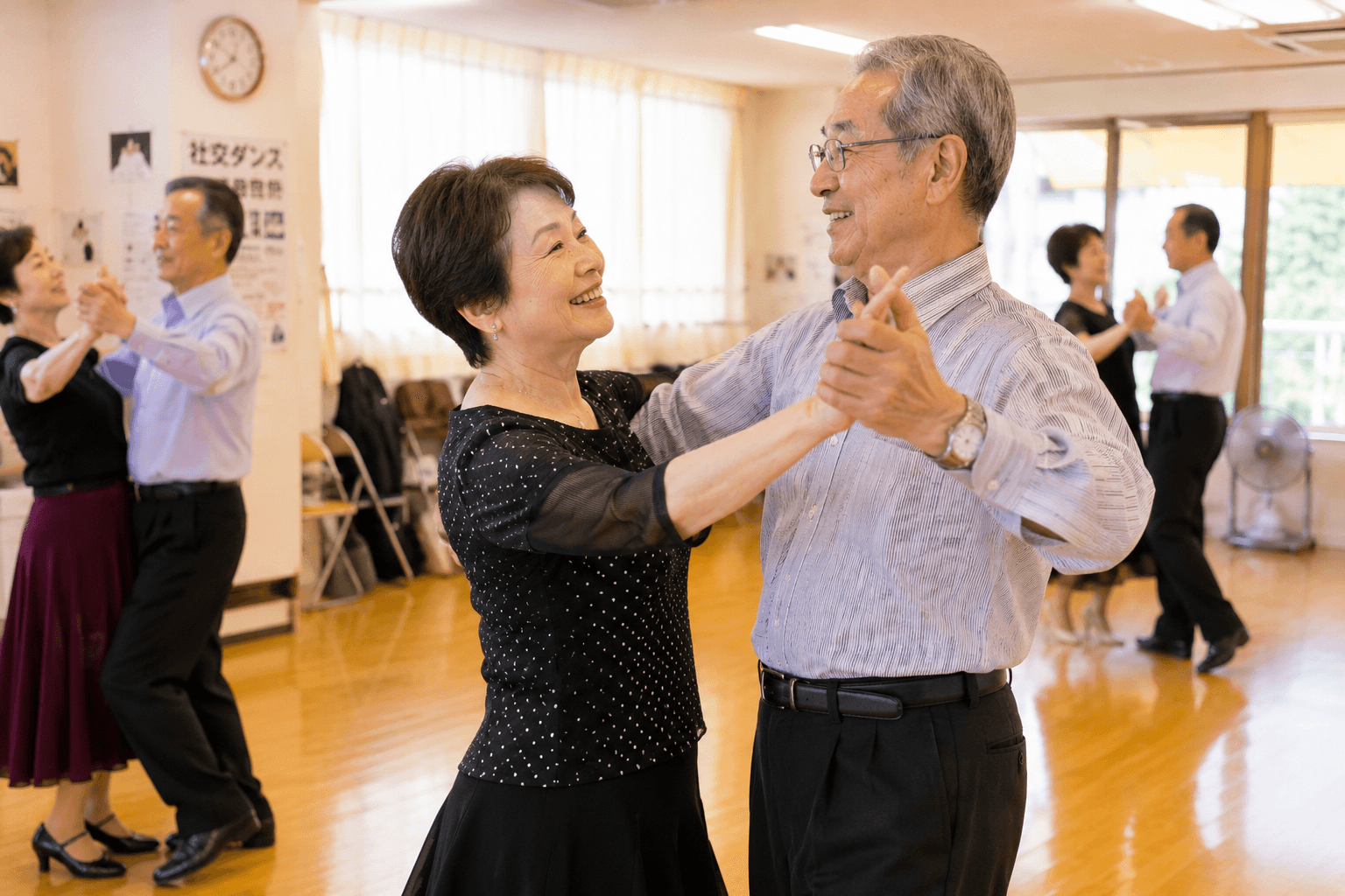 明るいスタジオで笑顔を見せながら社交ダンスを練習するカップルたち